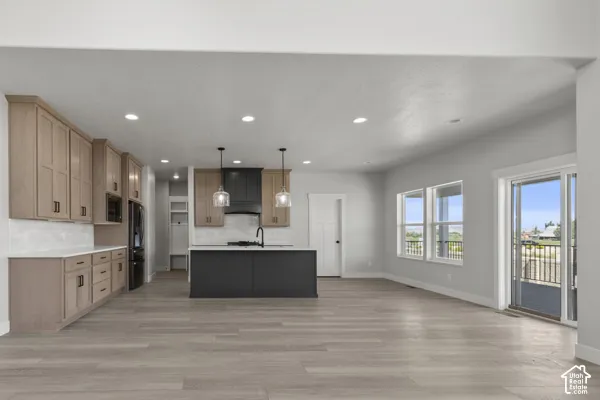 Kitchen featuring wood-finish cabinetry, a contrasting center island with a stone countertop, recessed lighting, and sliding glass doors