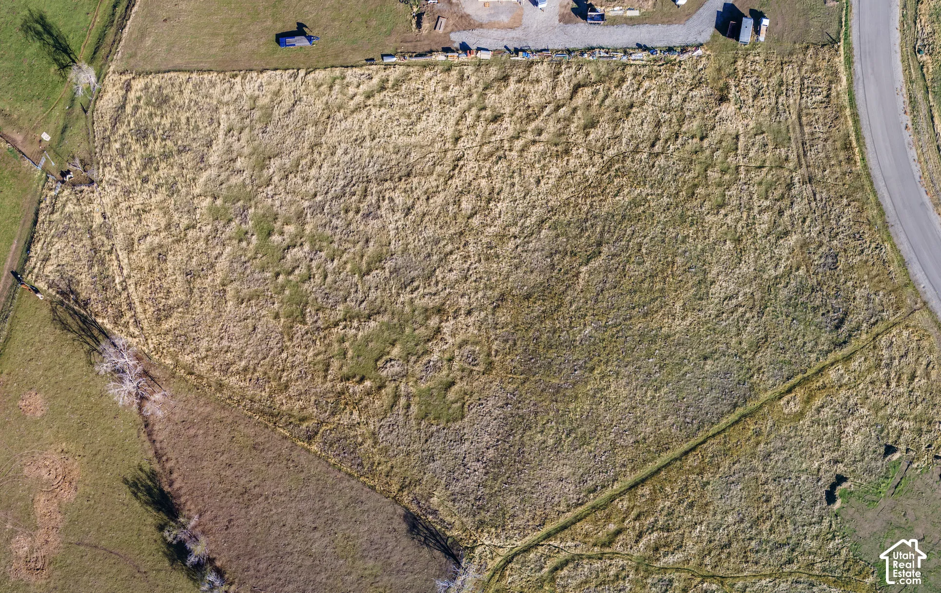 Expansive parcel of open land featuring direct paved road access and established topography