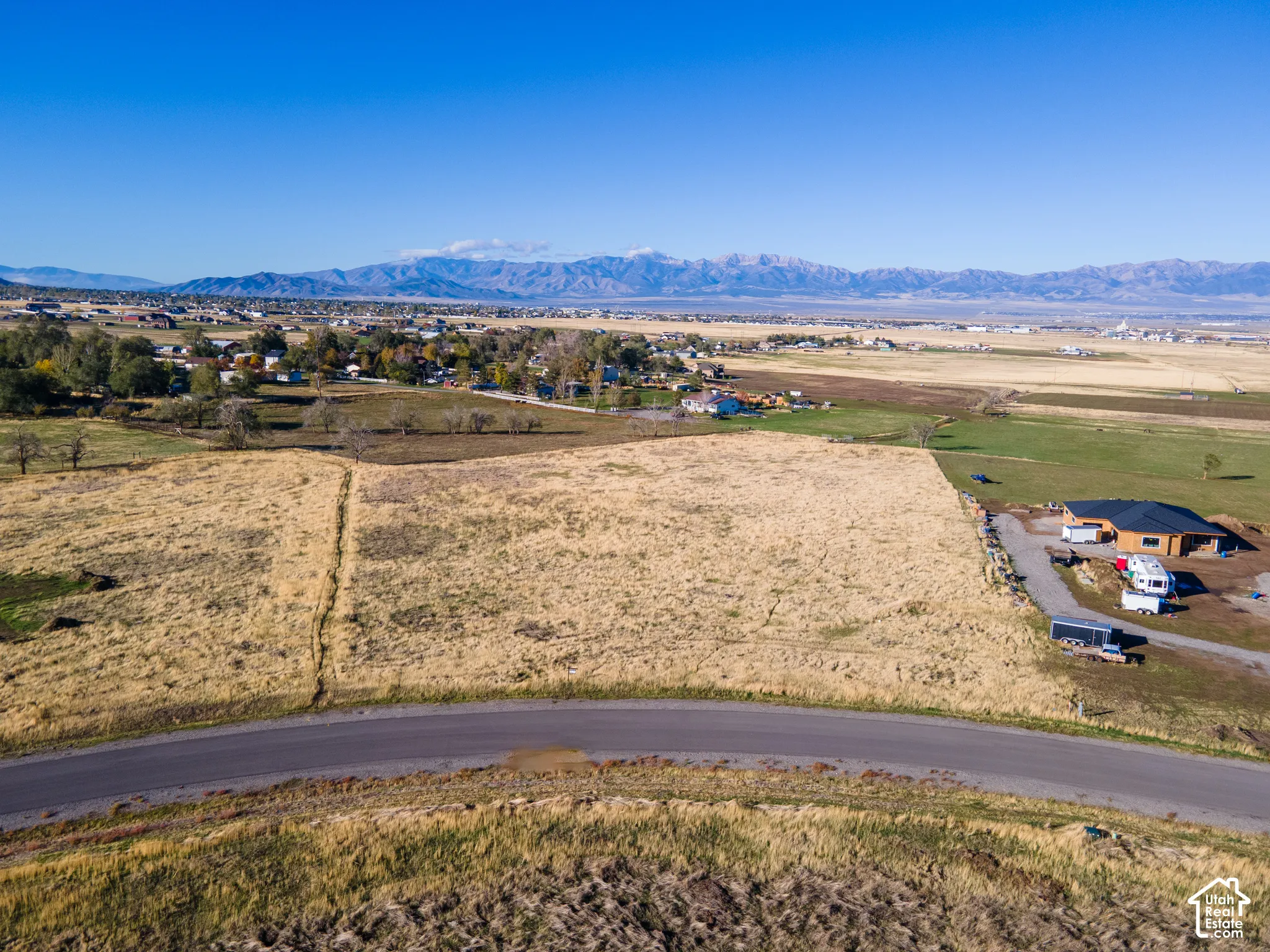 Expansive vacant parcel featuring paved road frontage, natural topography, and panoramic mountain backdrop