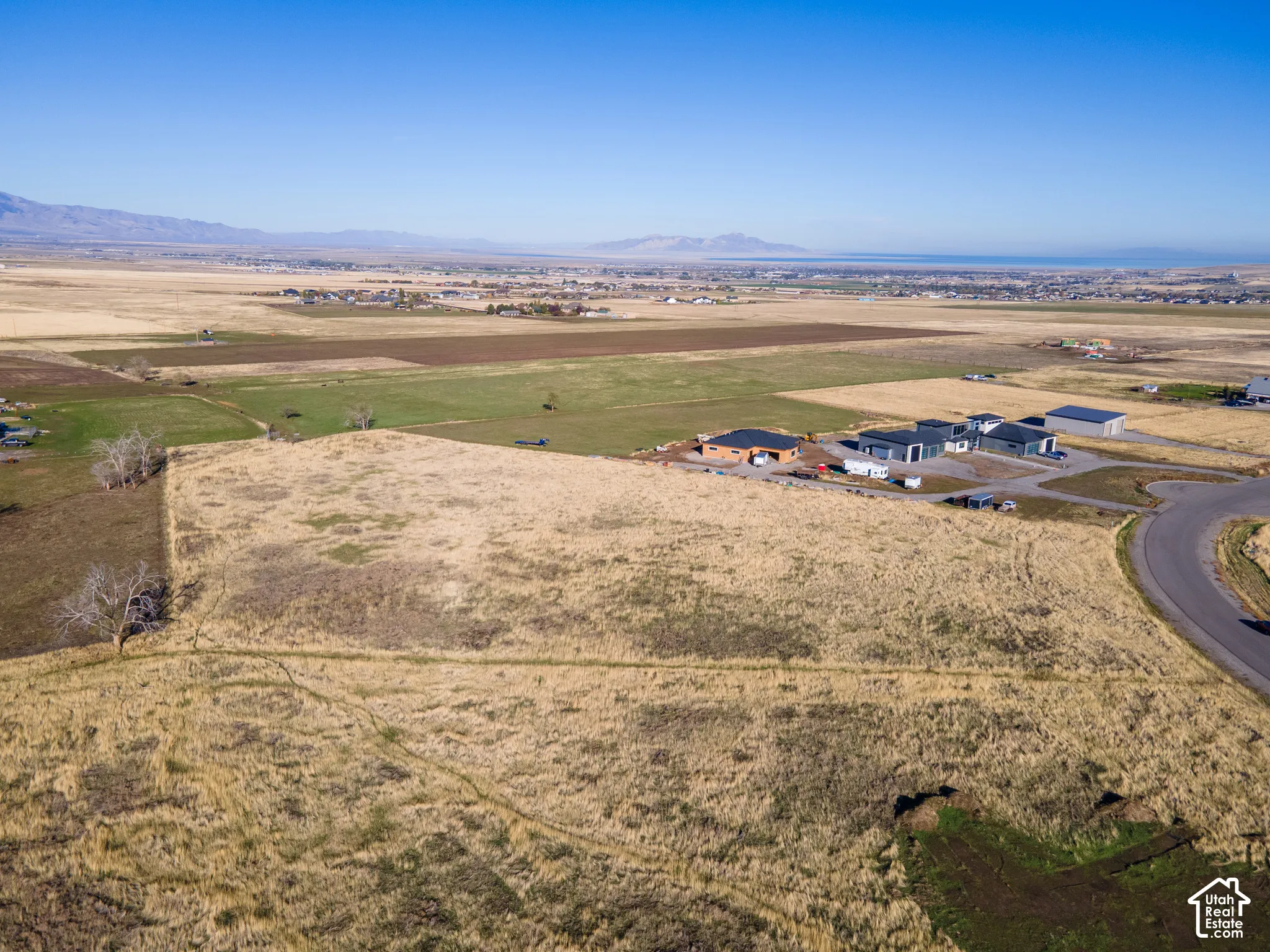Expansive undeveloped acreage featuring native grasses, prominent mountain backdrops, and paved road access