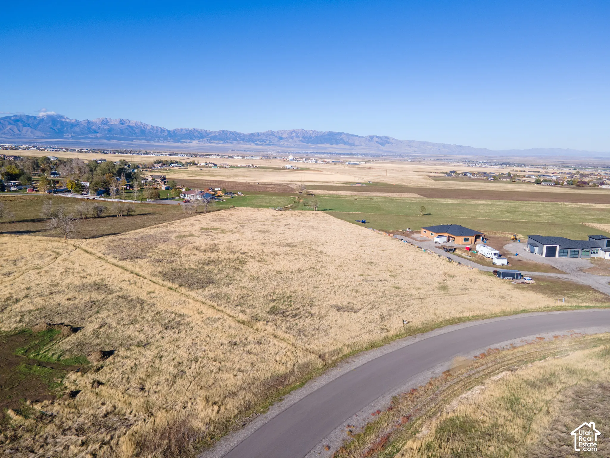 Expansive undeveloped lot with asphalt road frontage and mountain range backdrop