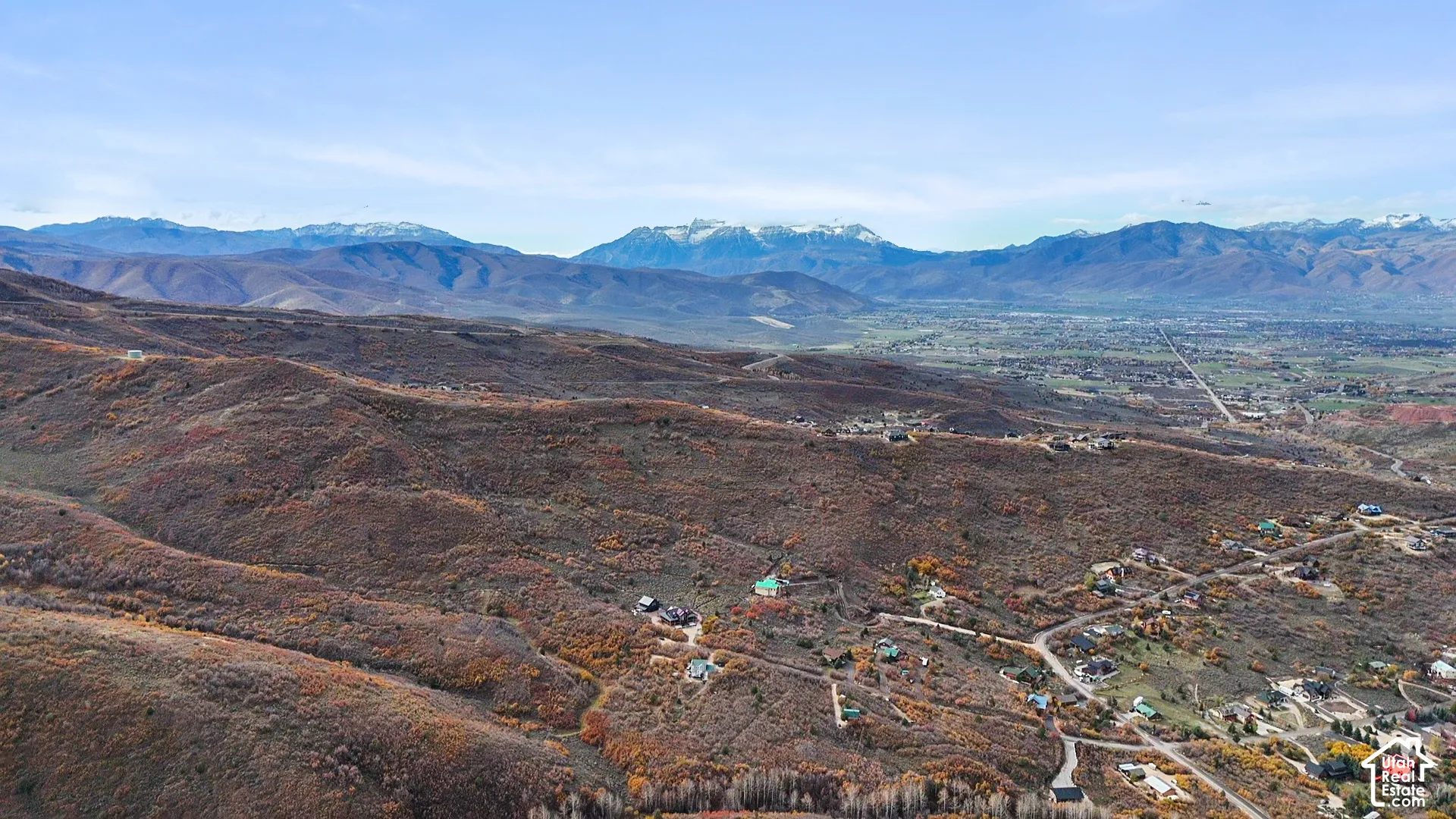 Aerial perspective of a hillside property featuring expansive mountain scenery, ridgeline topography, and natural vegetation