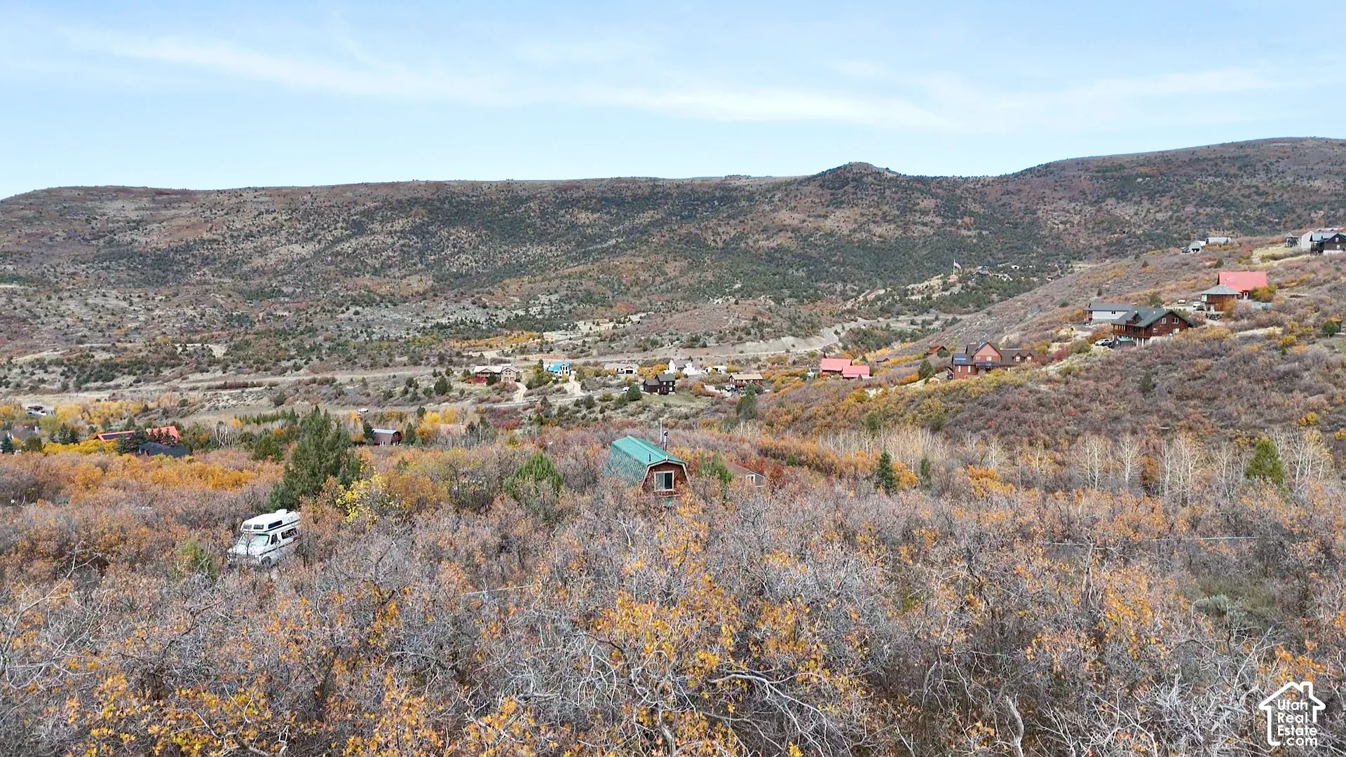 Expansive mountain landscape featuring varied topography, dense deciduous vegetation, and mature trees