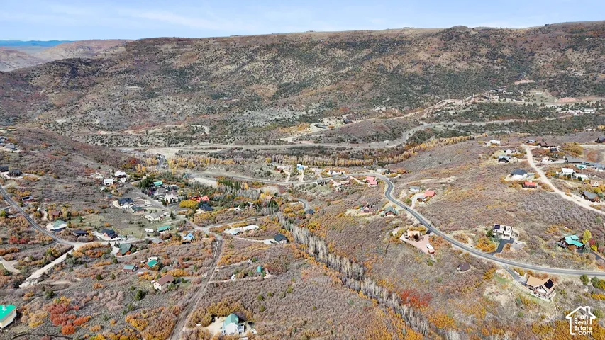 Aerial perspective featuring expansive mountainous terrain, native desert vegetation, and winding paved roadway infrastructure