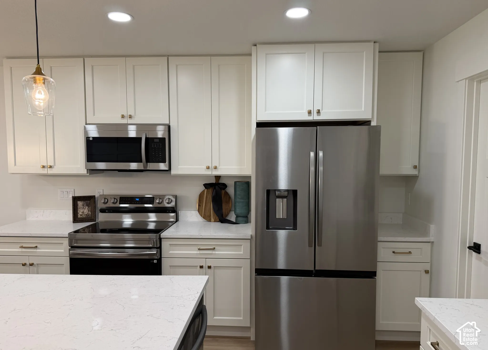 Kitchen featuring white shaker-style cabinetry, stainless steel appliances, white countertops, a glass pendant light, and recessed lighting