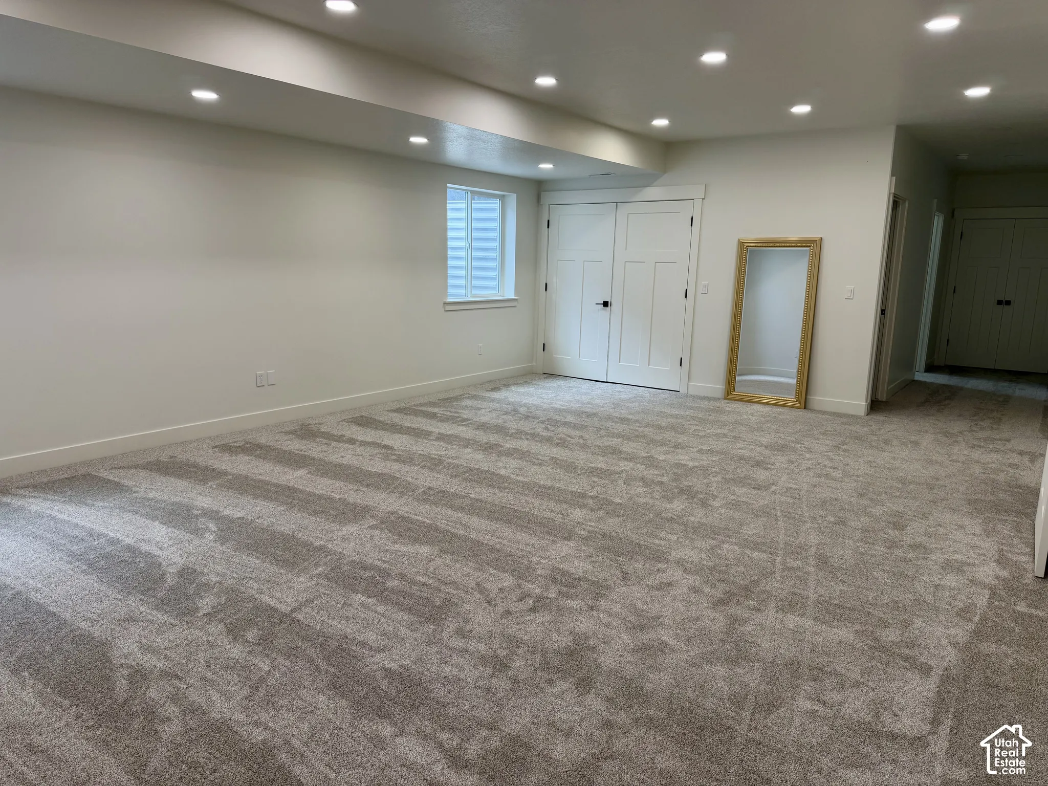 Open-concept area featuring recessed ceiling lighting, wall-to-wall carpeting, and double-door storage closet