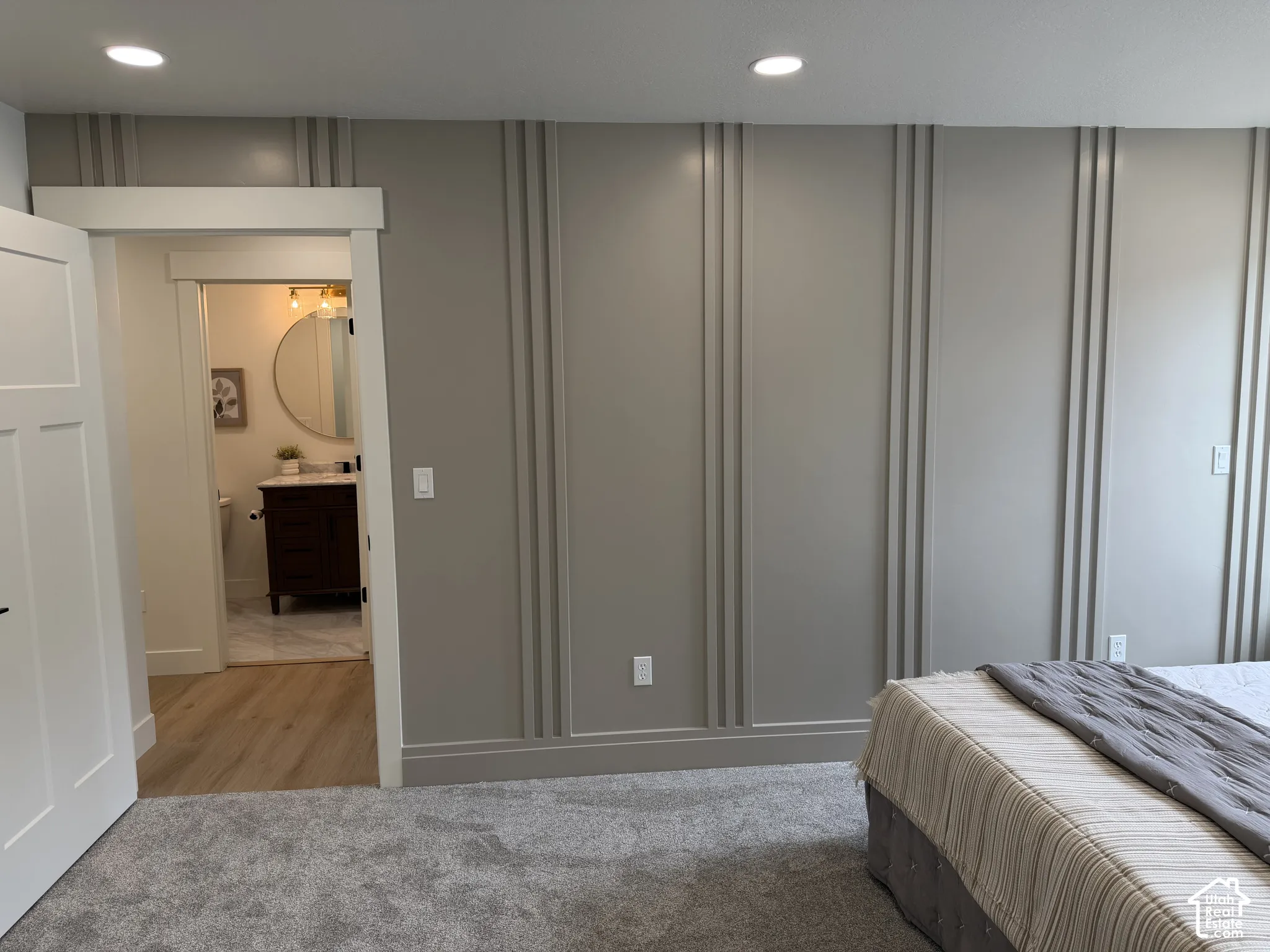 Accent wall featuring vertical board-and-batten millwork, recessed ceiling lighting, and crisp door trim