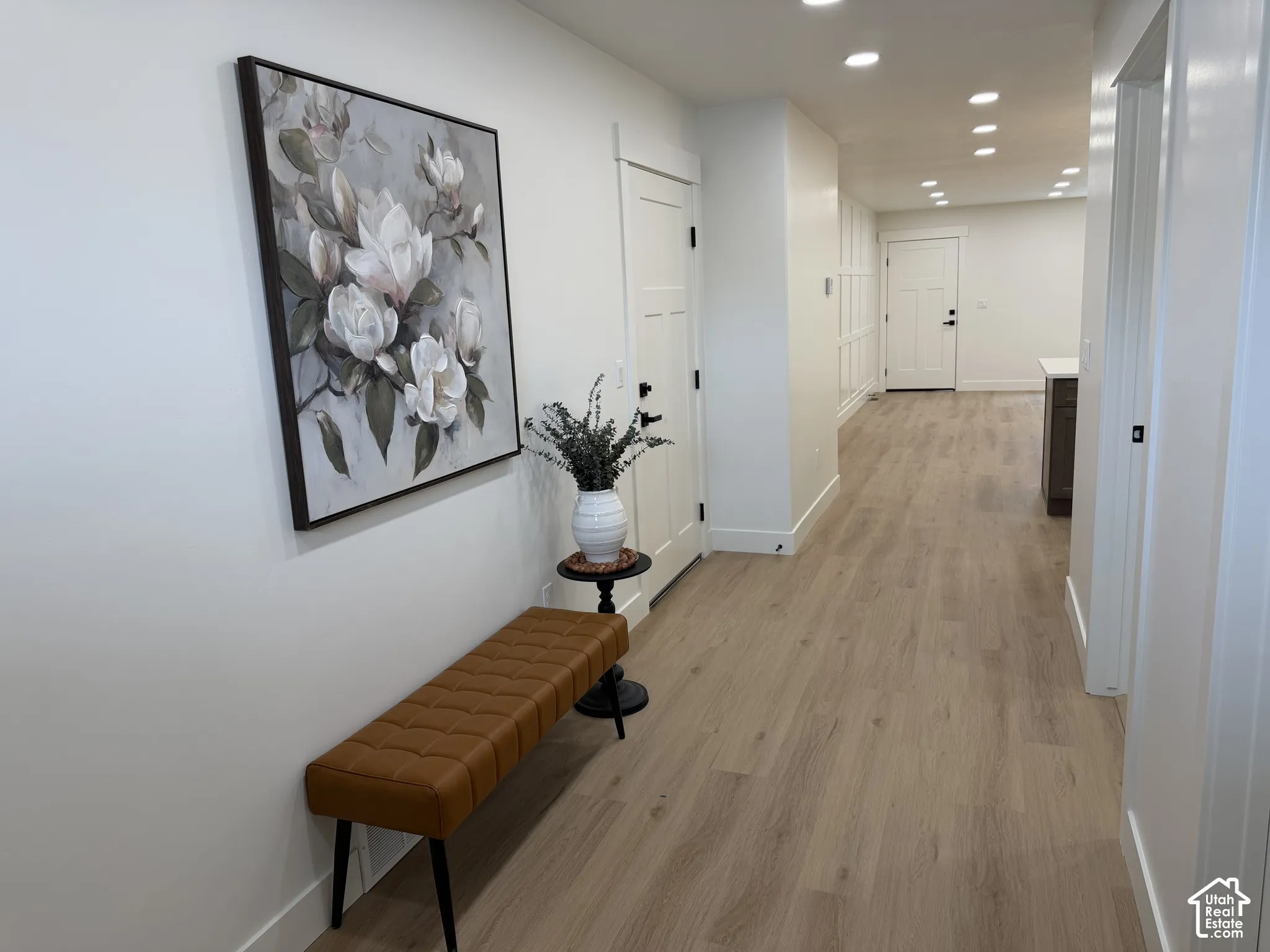 Interior hallway featuring wood-finish flooring, recessed lighting, shaker-style interior doors, and custom board-and-batten wall detailing