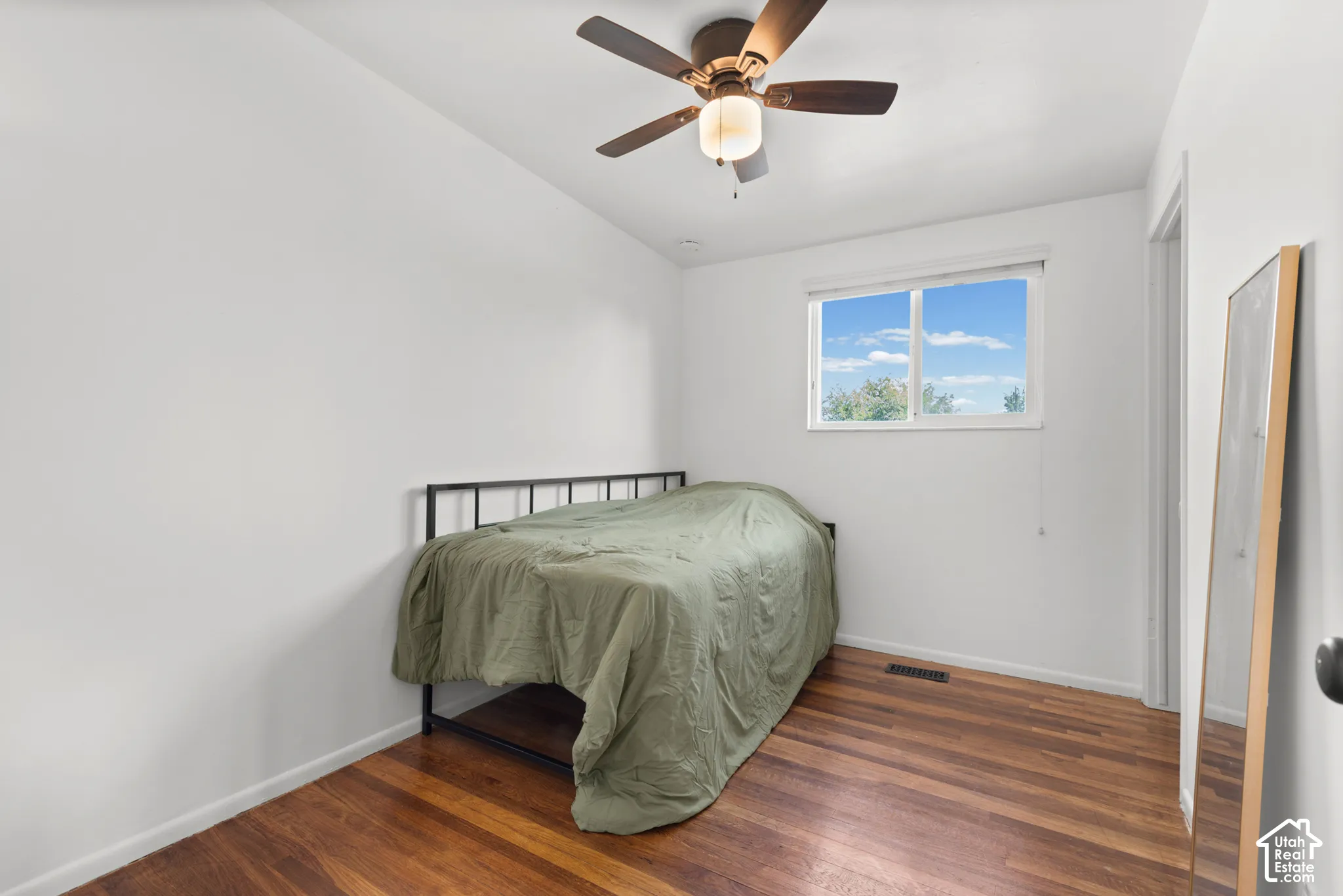 Interior room featuring wood-finish flooring, a ceiling fan with integrated lighting, and a horizontal sliding window
