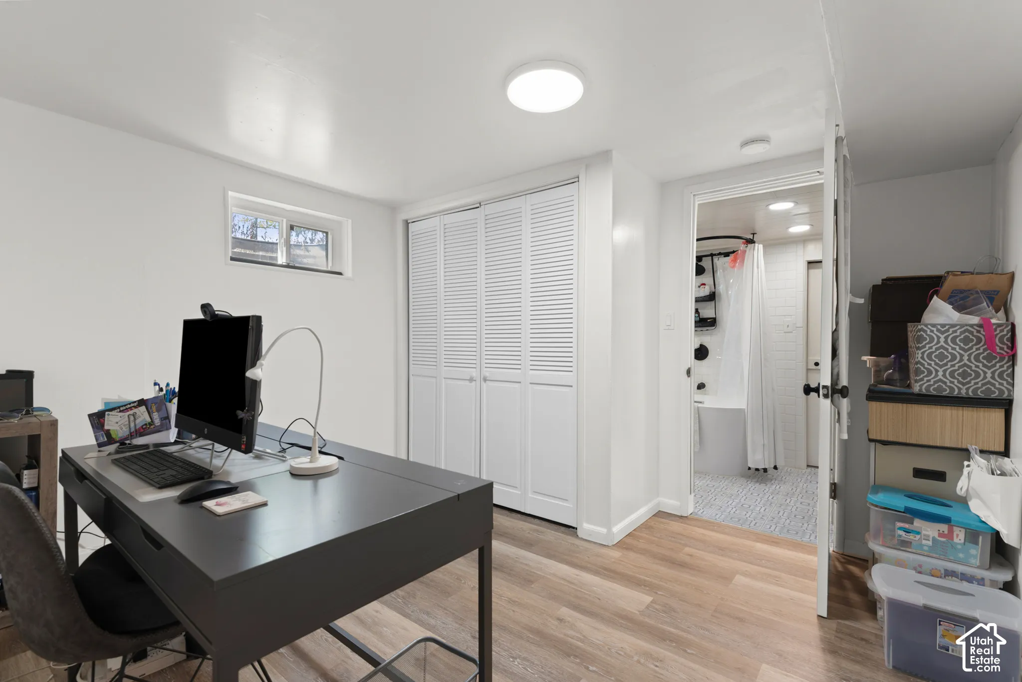 Room featuring wood-finish flooring, white louvered closet doors, a recessed window, and flush-mount ceiling lighting