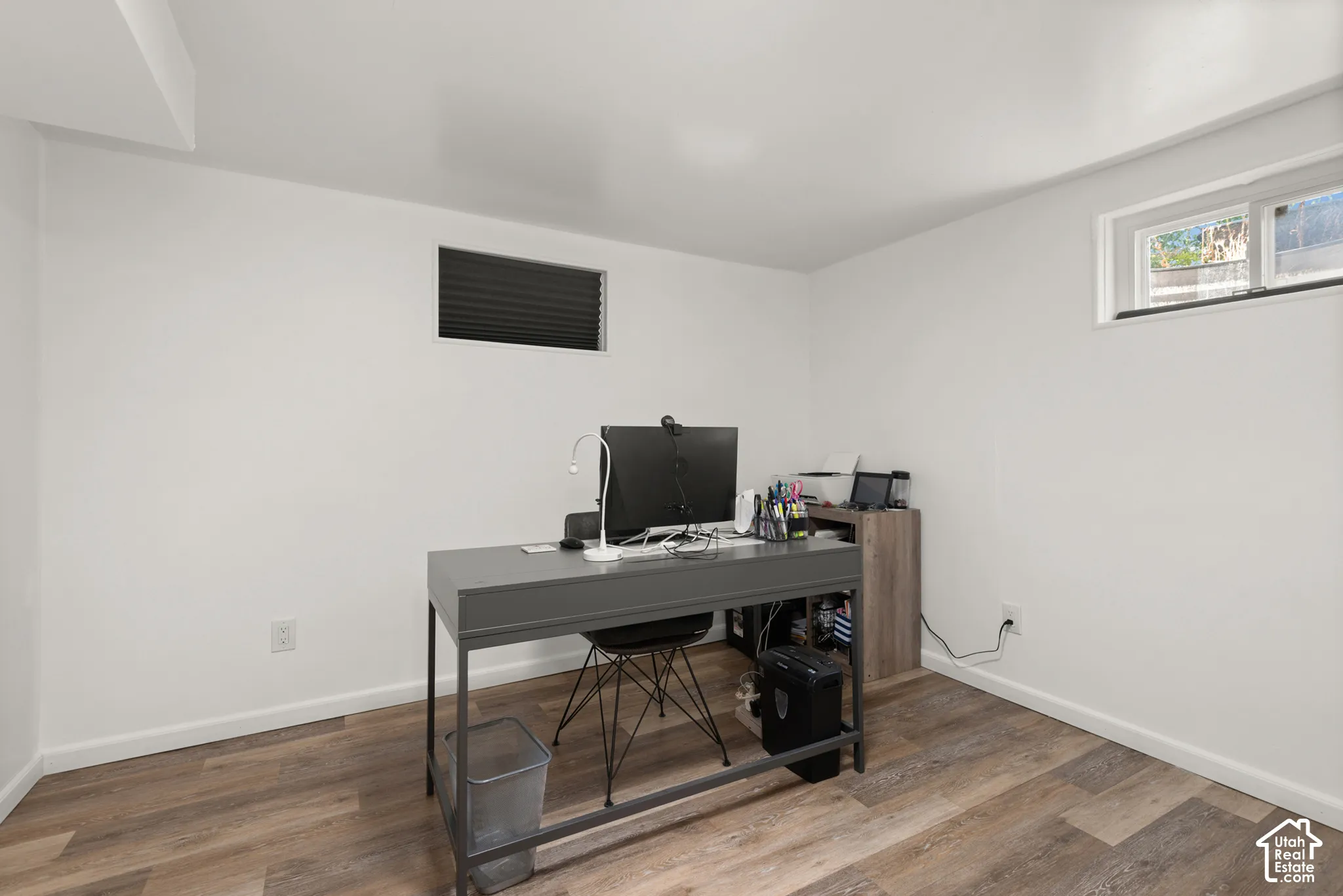 Interior space featuring wood-finish flooring, white walls, and dual windows
