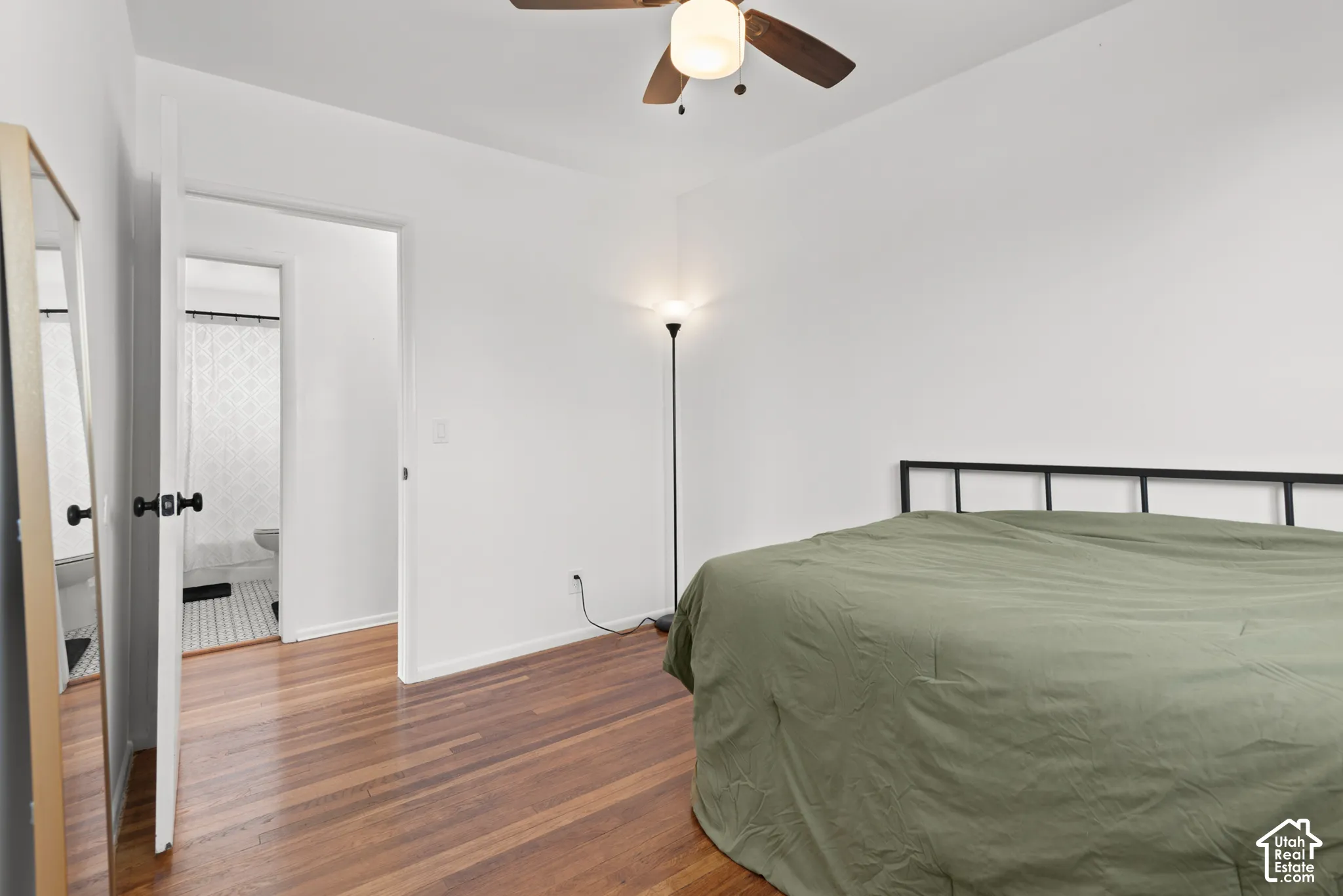 Room featuring wood-finish flooring, a ceiling fan with integrated lighting, and a neutral color palette