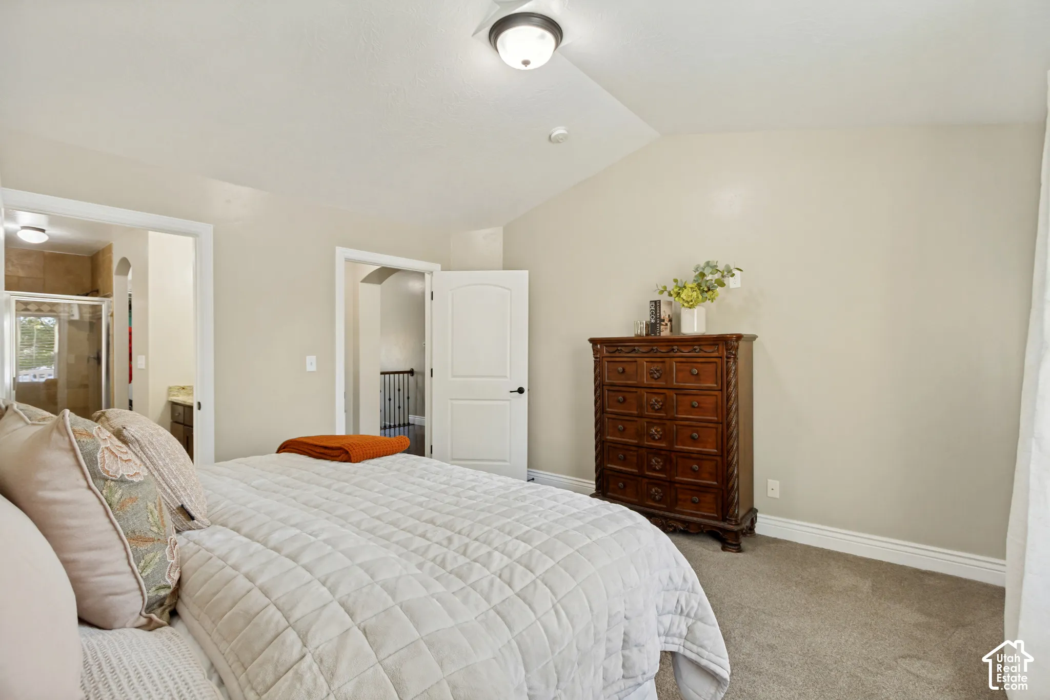 Vaulted ceiling, neutral wall tones, carpeted flooring, and a semi-flush mount light fixture