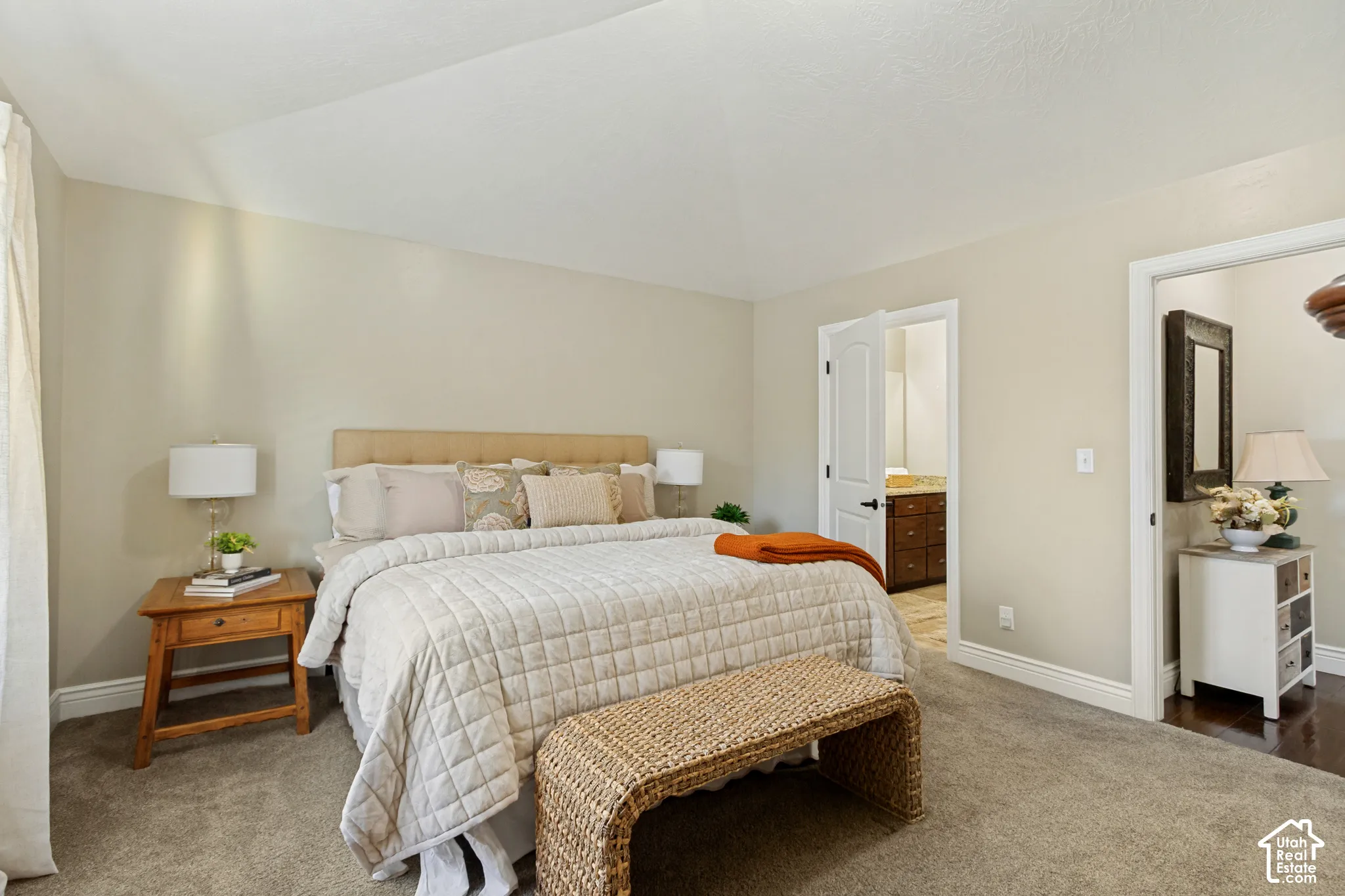 Neutral wall palette, vaulted ceiling, carpeting, and two doorways with interior access