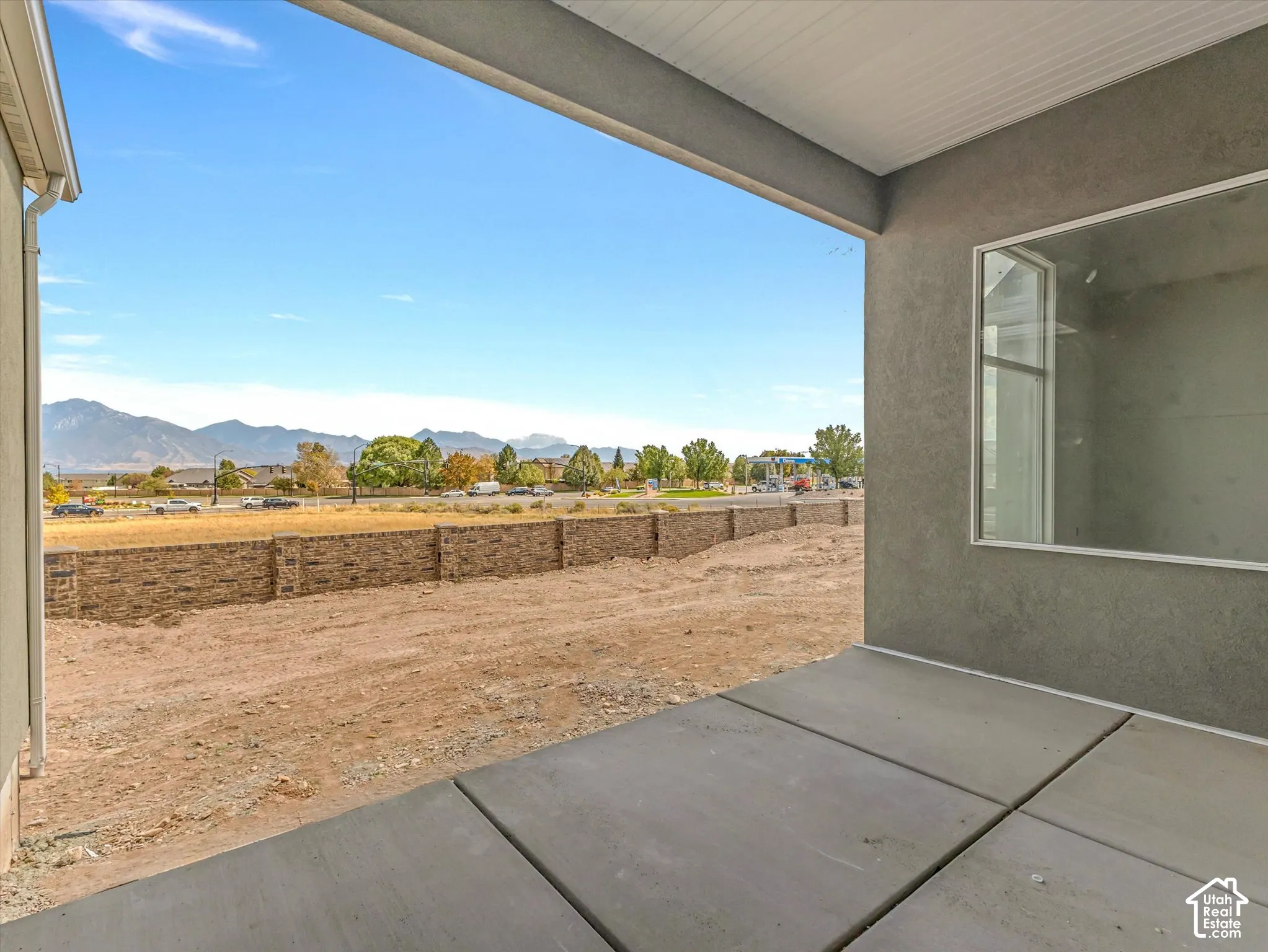Covered concrete patio with recessed ceiling, exterior stucco finish, and mountain scenery