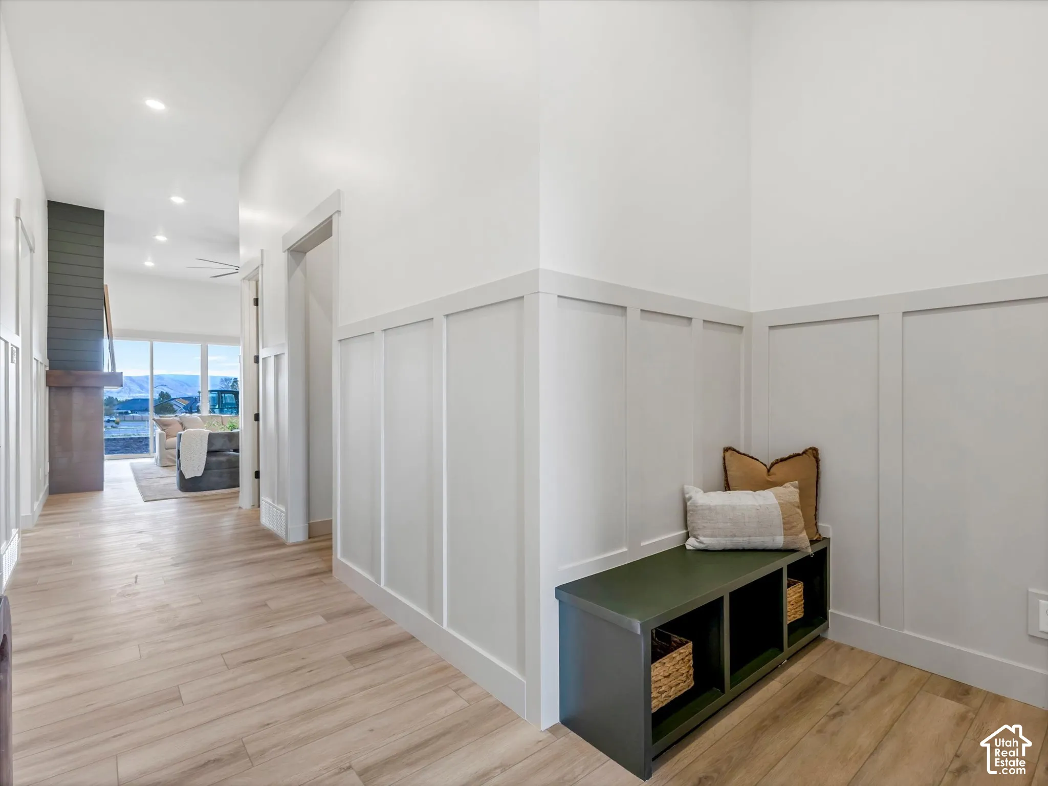 Entryway featuring light wood-finish flooring, custom wall paneling, and recessed lighting
