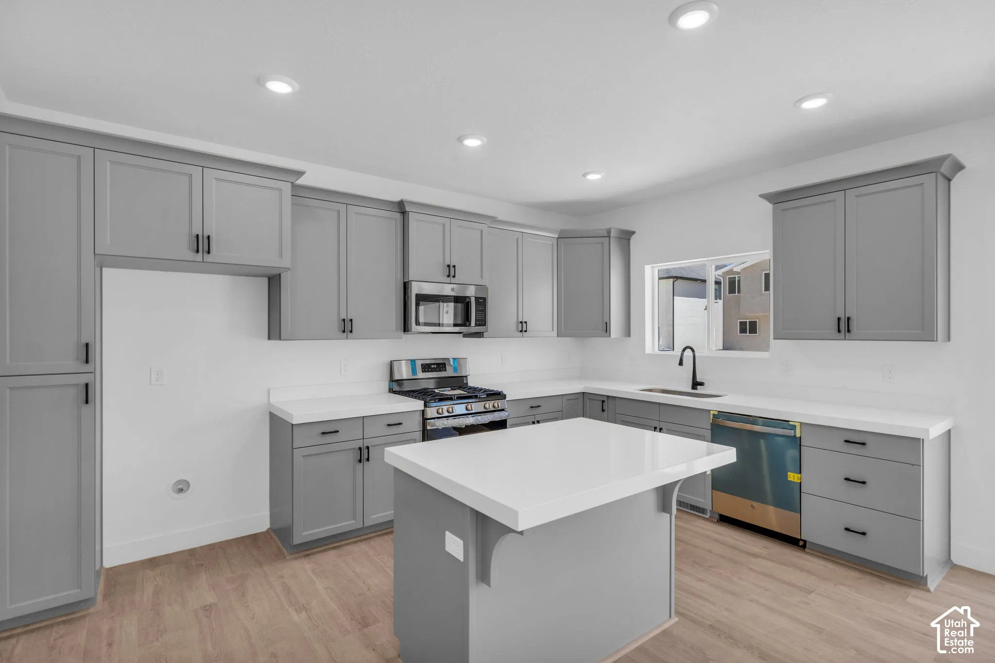 Terrific kitchen with 42" uppers, painted wood cabinets, quartz slab countertops, large walk-in pantry, gas range, microwave, dishwasher and disposal