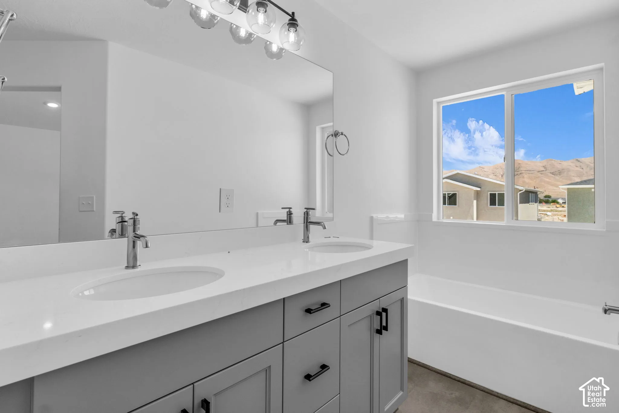 Primary bath with dual sinks, painted cabinets, quartz slab countertop, soaker tub and walk-in shower.