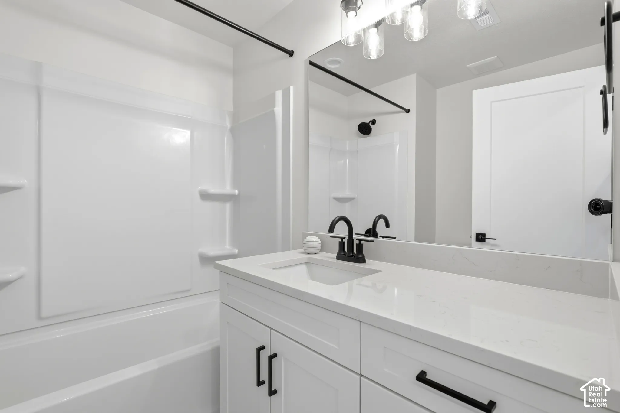 Vanity with white countertop, integrated sink, and matte black faucet