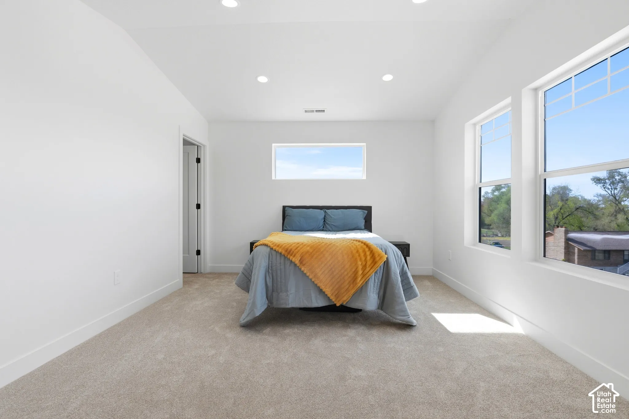 Plush carpeting, recessed lighting, and multiple windows