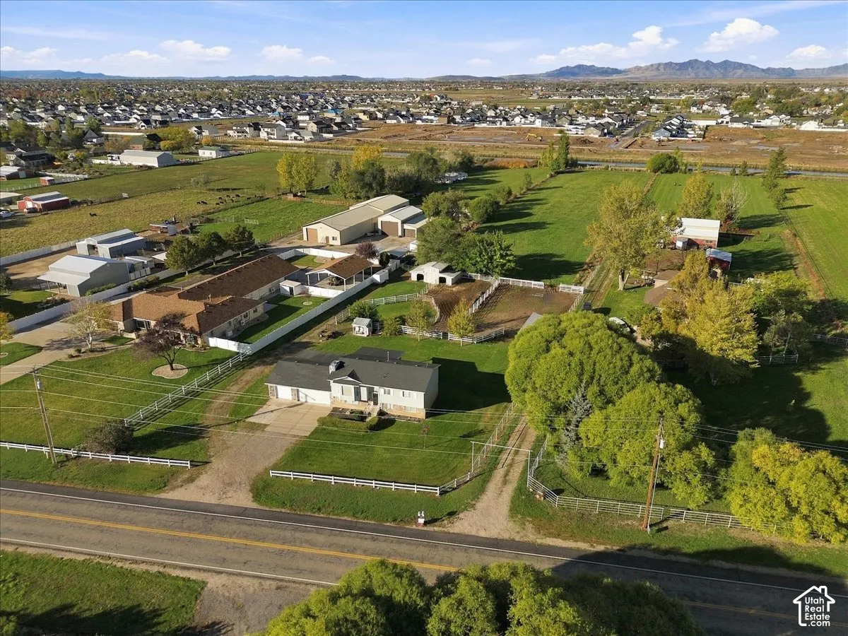 Expansive acreage featuring multiple outbuildings, fenced paddocks, manicured lawn areas, and mature trees