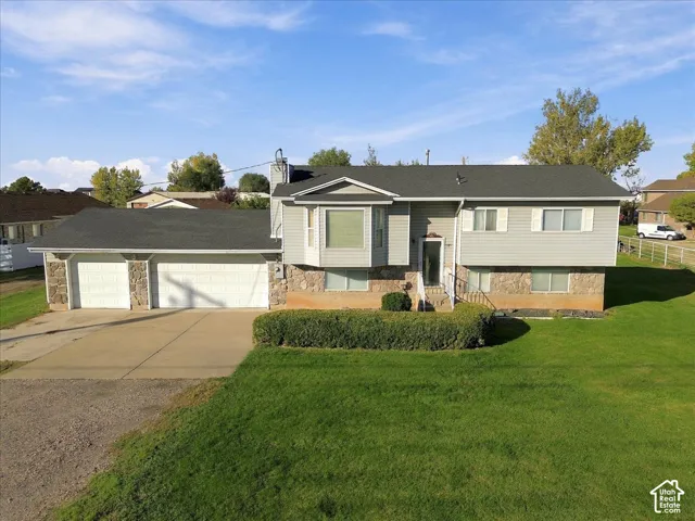 Exterior combination of stone and horizontal siding, an attached two-car garage, a bay window, and a shingled roof