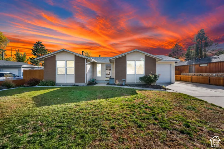 Single-story residence featuring a combination of siding and masonry exterior, an attached garage, a concrete driveway, and a front lawn