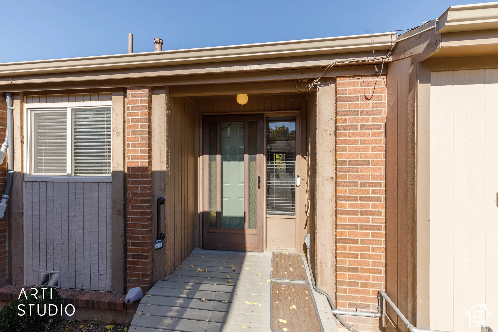 Exterior entrance featuring brick masonry siding, a multi-pane glass entry door, and a dedicated ramp access
