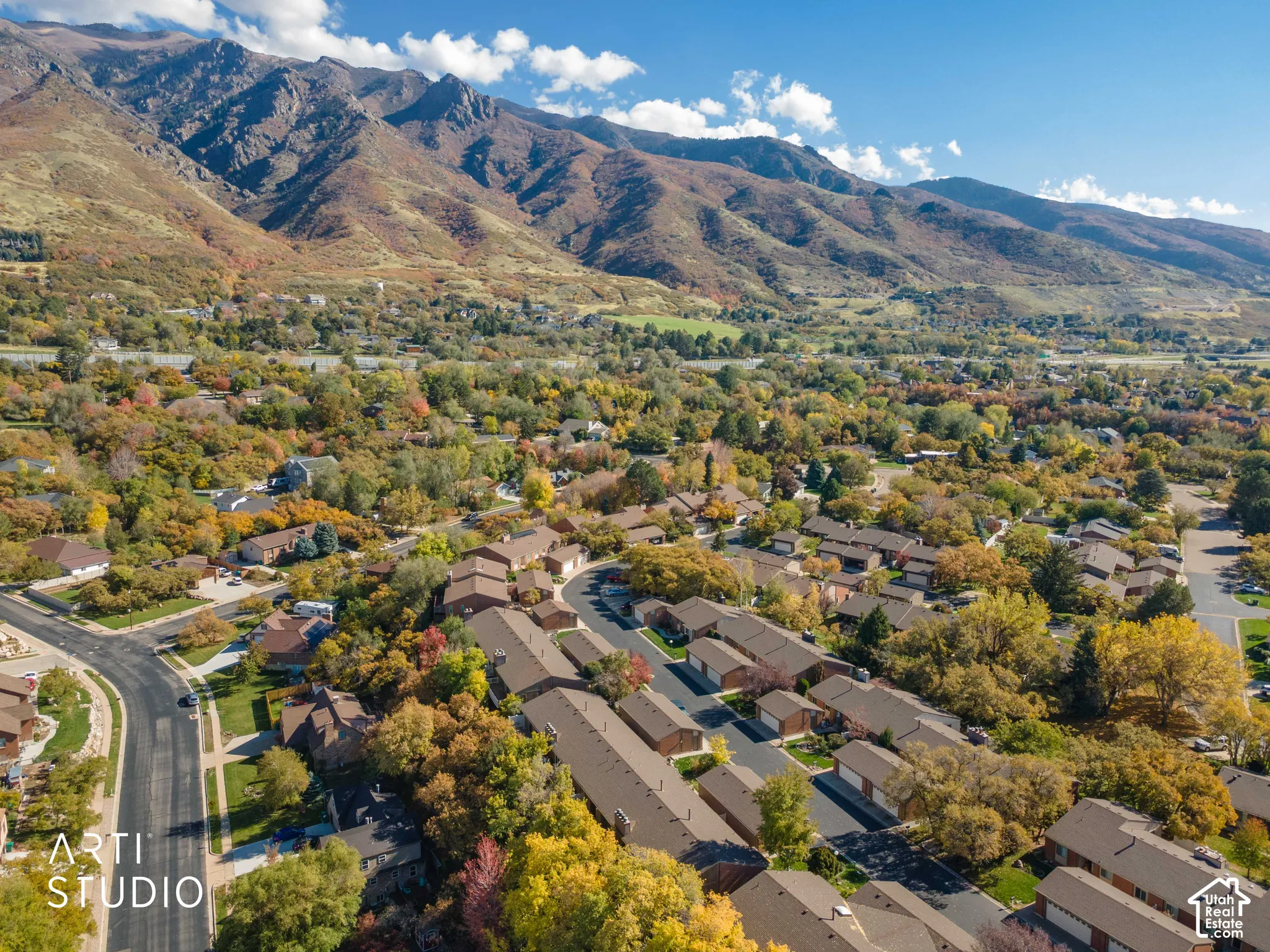 Aerial perspective showcasing expansive mountain terrain with established residential density and mature deciduous trees