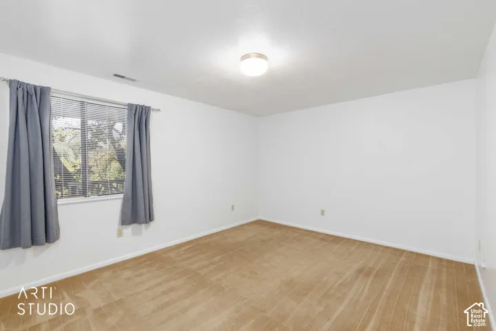 Neutral-toned carpeting, white walls, and a ceiling-mounted light fixture