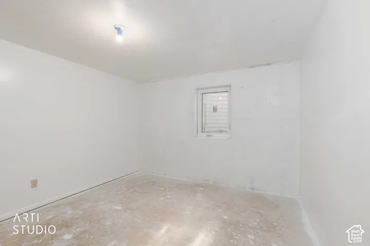 Neutral-toned room featuring a single-pane window with white frame and a central ceiling light fixture