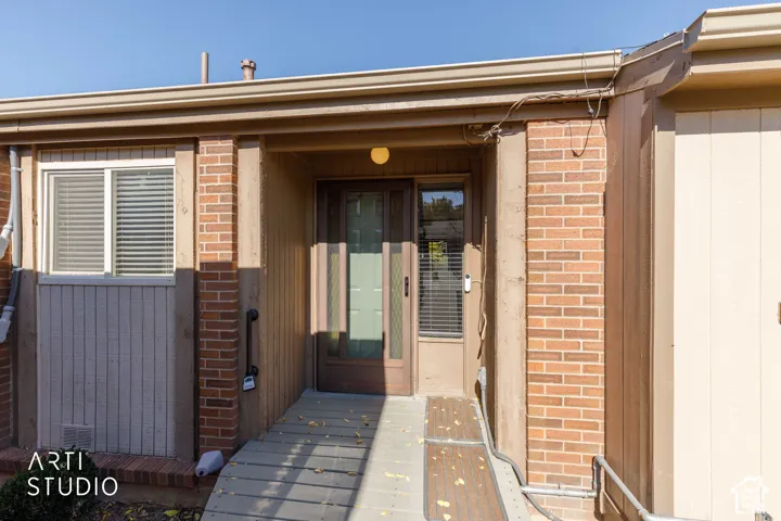 Exterior entrance featuring brick masonry siding, a multi-pane glass entry door, and a dedicated ramp access