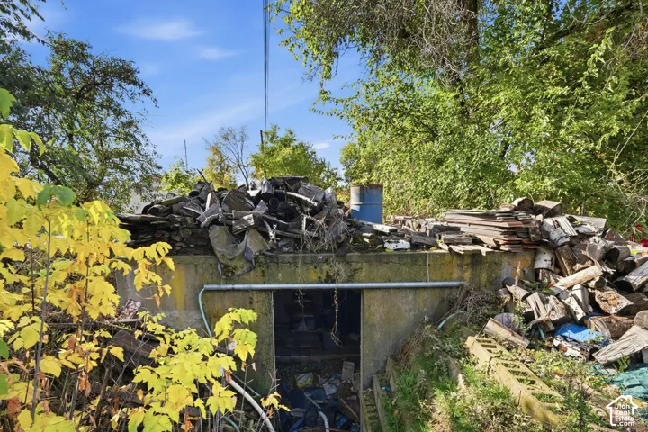 Concrete structure featuring an exterior subterranean entrance and mature trees