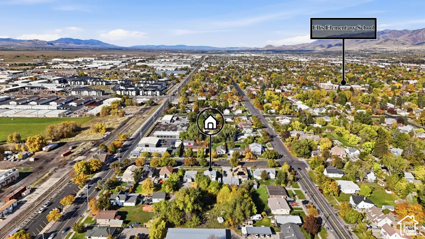 Aerial perspective featuring mountain topography, mature deciduous trees, and an established residential street layout