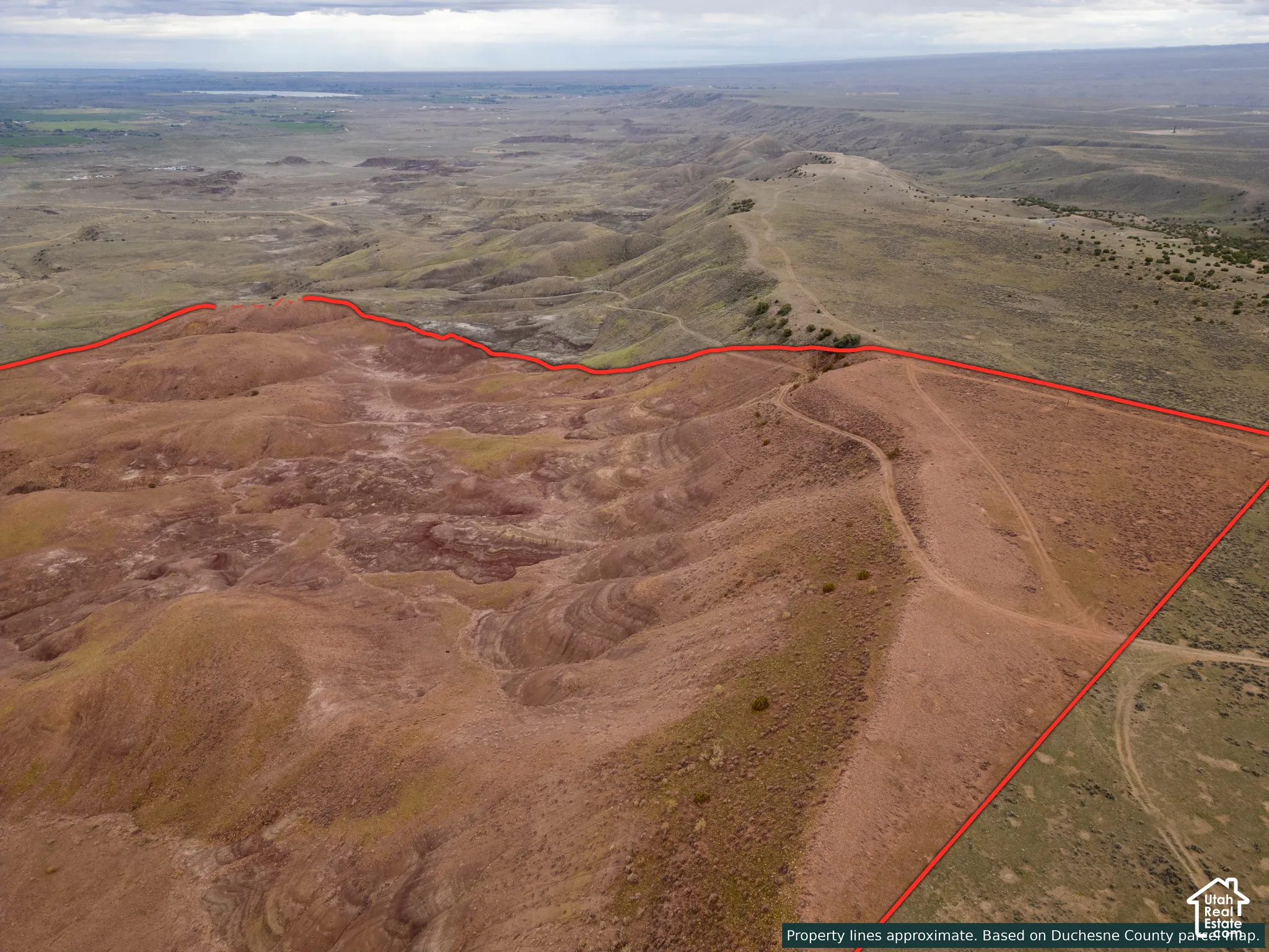 Expansive desert acreage featuring natural rock formations, rolling terrain, and dirt access trails