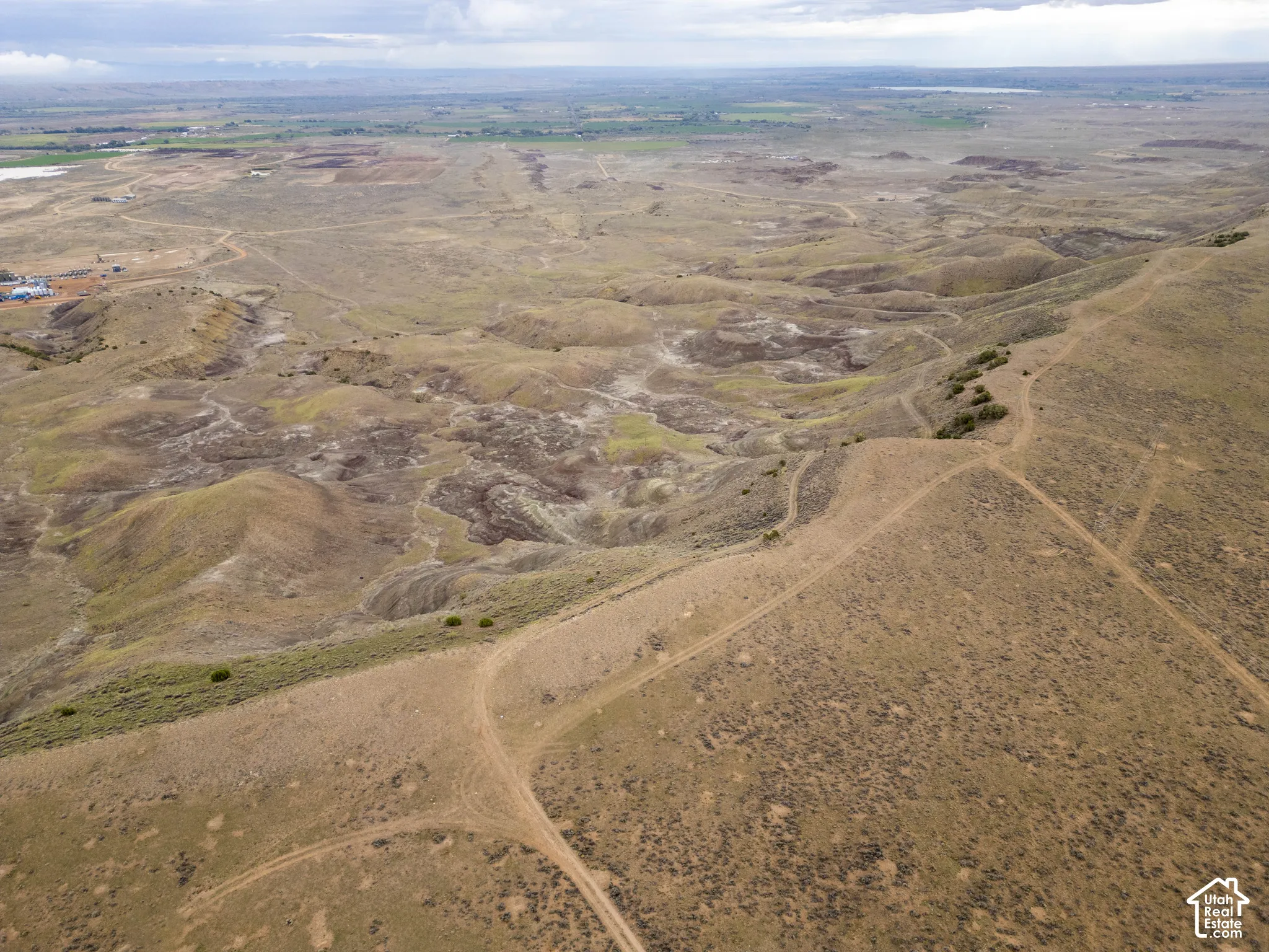 Expansive acreage characterized by undulating topography, native scrub vegetation, and unimproved earthen trails