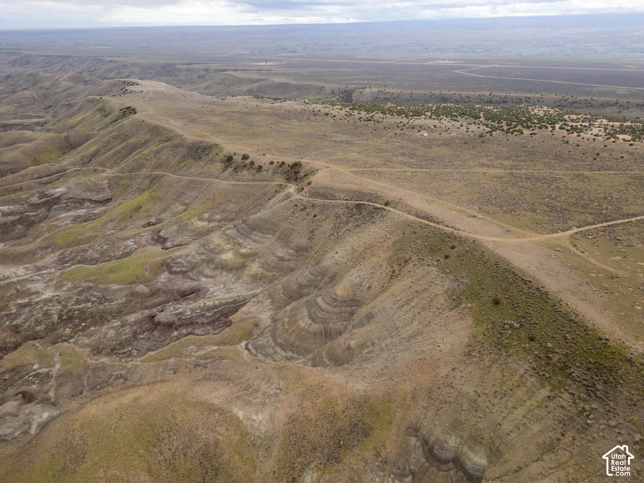 Expansive desert acreage featuring natural ridgeline topography, layered geological formations, and native scrub vegetation