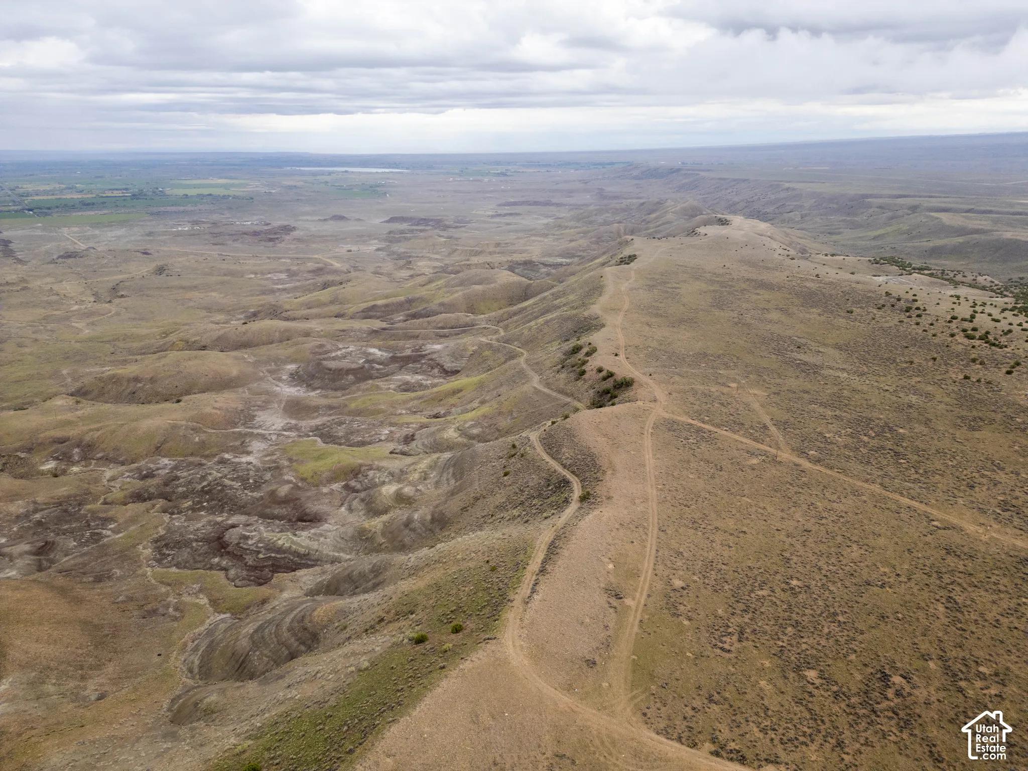 Aerial perspective of expansive acreage featuring rolling topography, native vegetation, and earthen trails