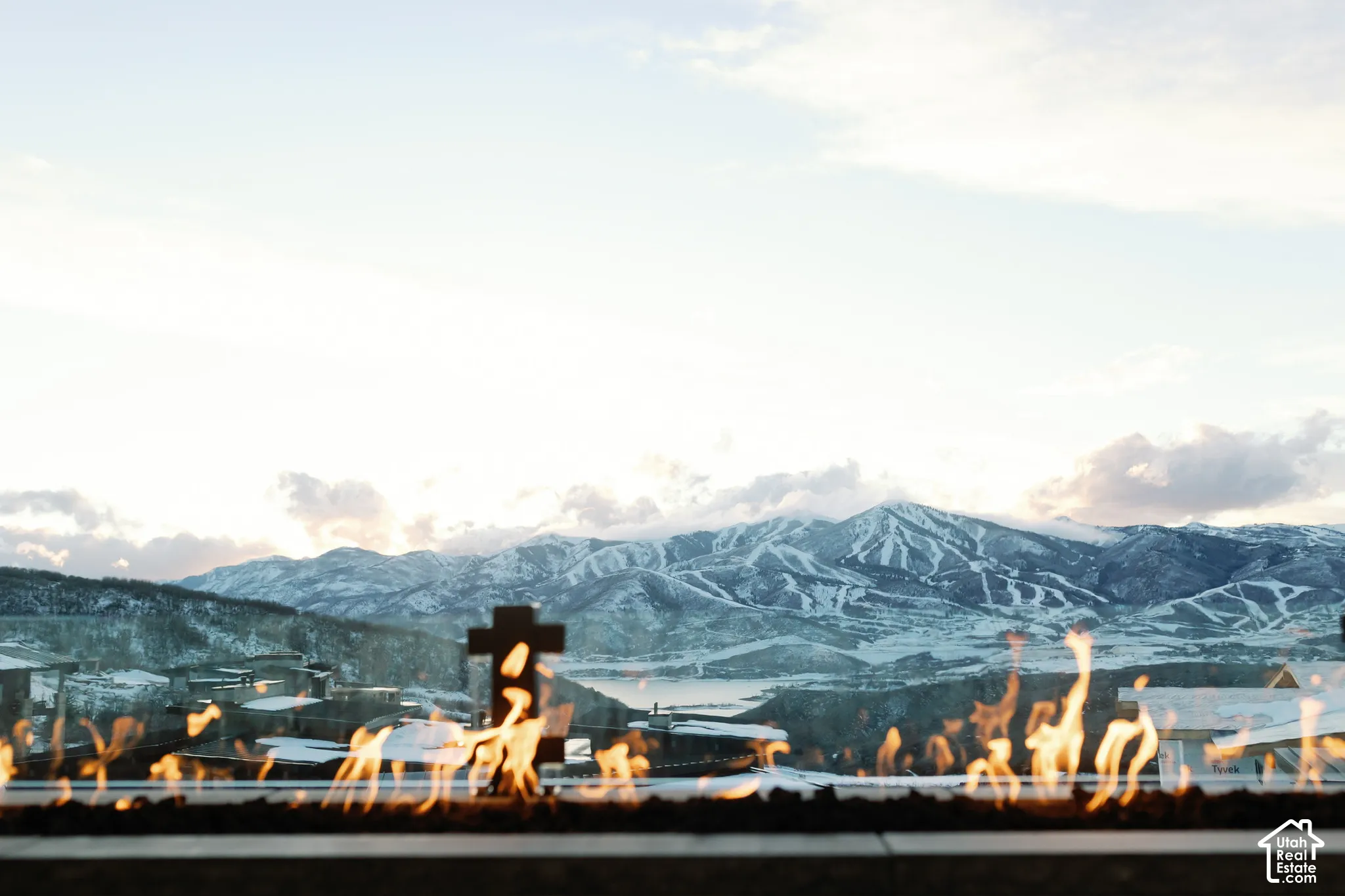 Linear outdoor fire feature with dark stone surround, set against a mountain backdrop