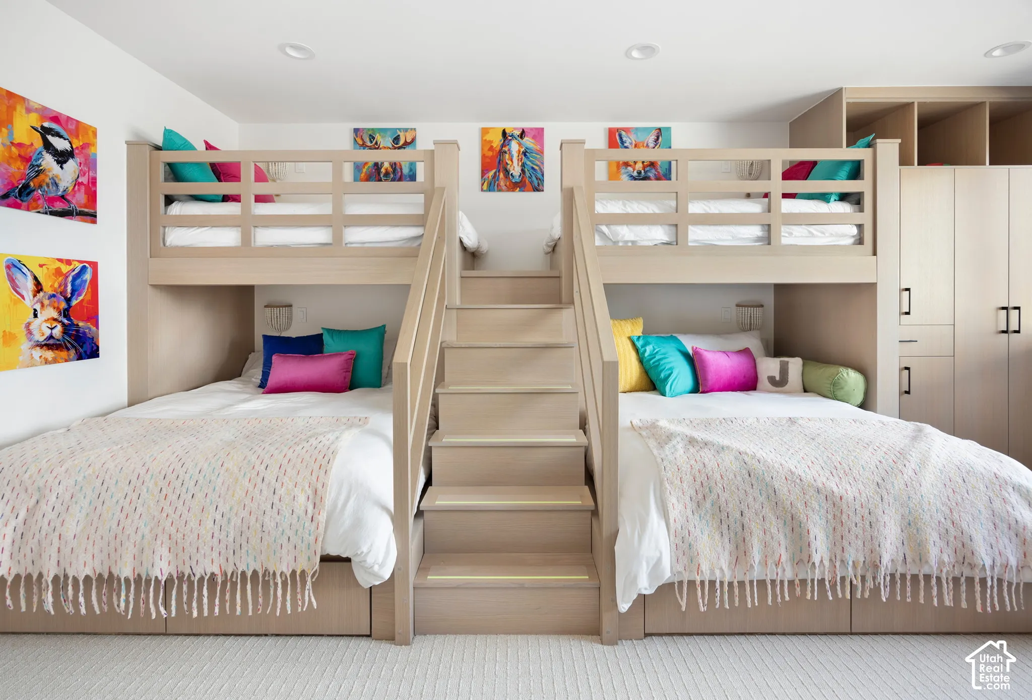 Custom built-in bunk beds featuring integrated stair access, recessed lighting, and expansive floor-to-ceiling cabinetry