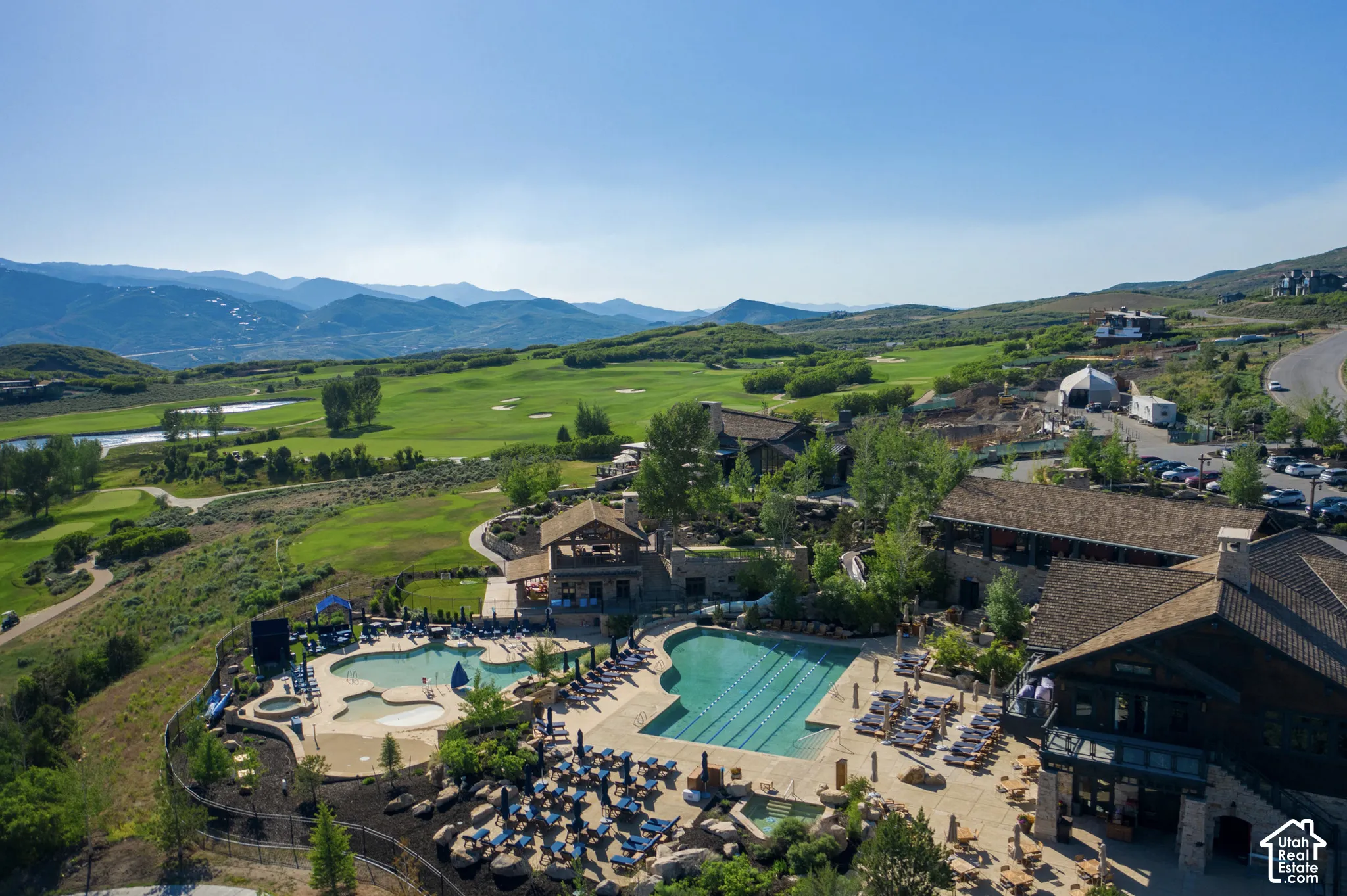 Multi-pool aquatic complex featuring a stone-paved deck, integrated hot tubs, and mountain scenery