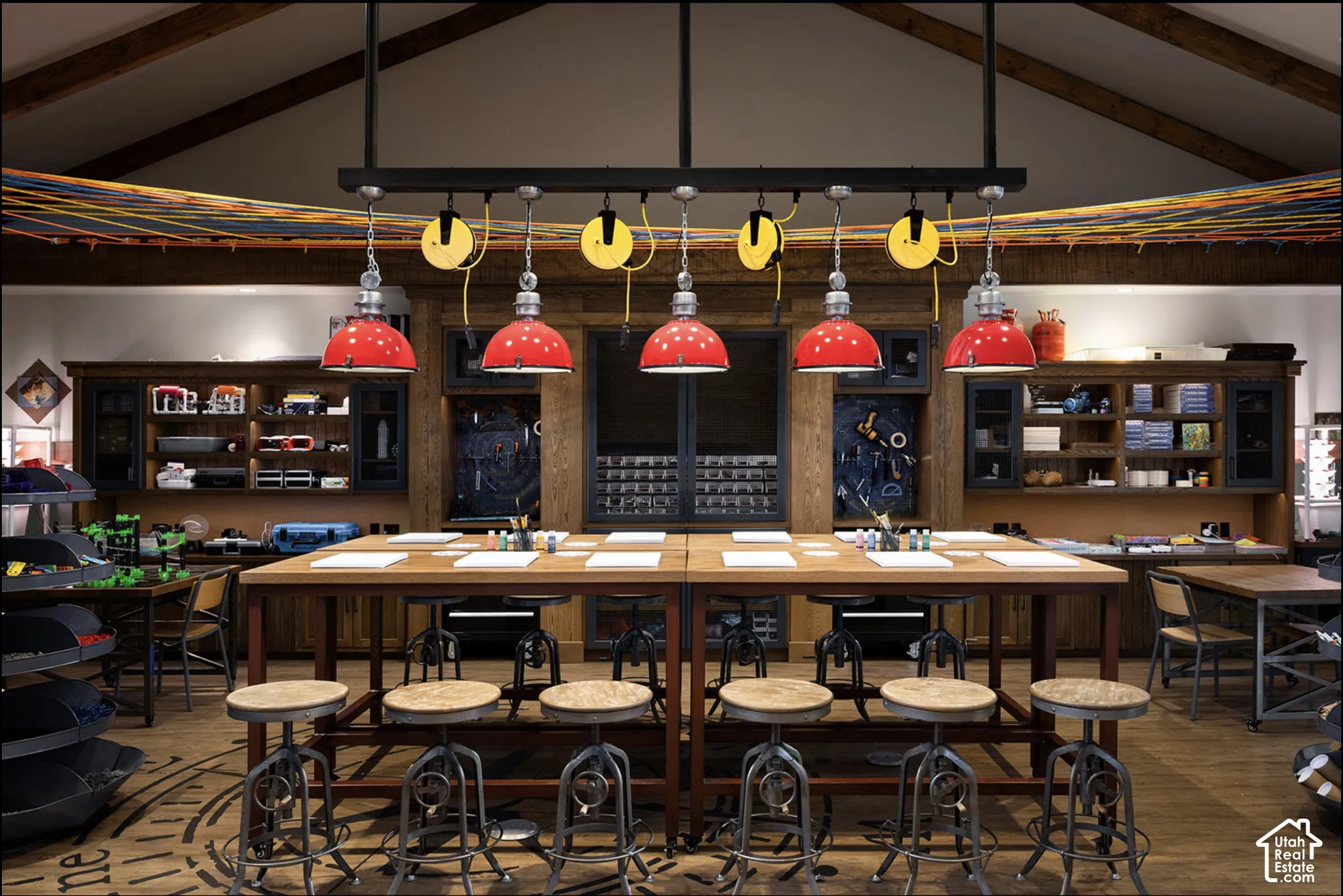 Vaulted ceiling with exposed wood beams, extensive built-in cabinetry, and industrial-style multi-pendant lighting fixture