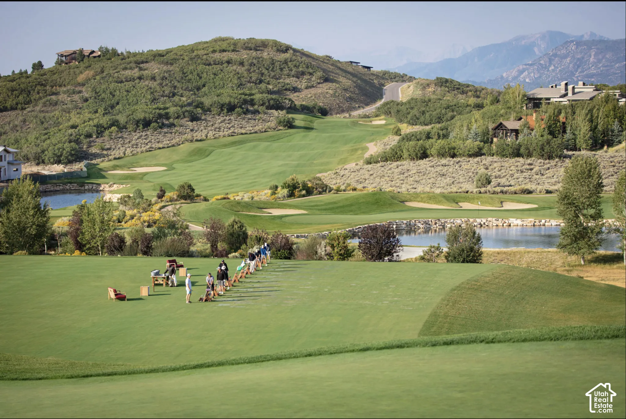 Golf course grounds featuring manicured fairways, sand bunkers, water features, and expansive mountain scenery