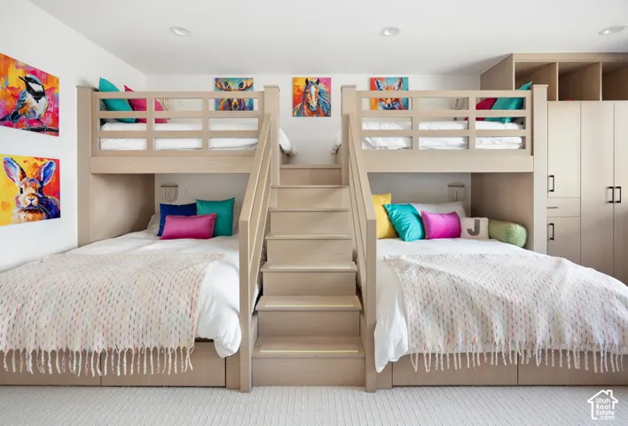 Custom built-in bunk beds featuring integrated stair access, recessed lighting, and expansive floor-to-ceiling cabinetry