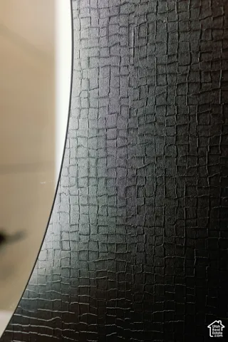 Black textured cabinet door featuring a subtle grid pattern and curved profile edge
