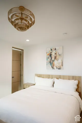 Multi-tiered woven rattan pendant light fixture, horizontal-grain wood-finish interior door with matte black hardware, and recessed ceiling lighting