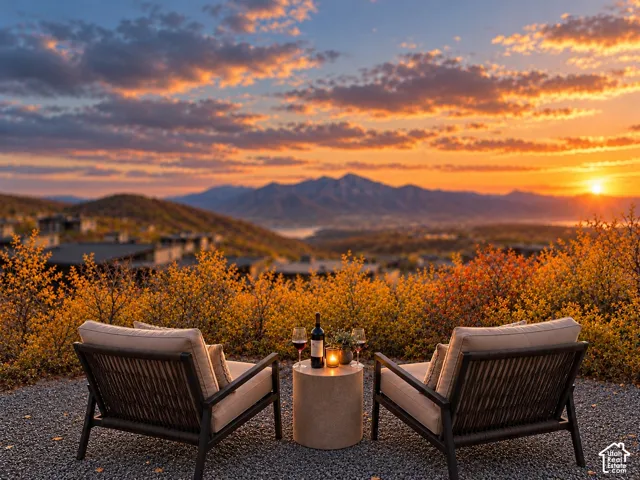 Gravel-surfaced patio featuring natural landscaping, prominent mountain topography, and sunset-lit horizon
