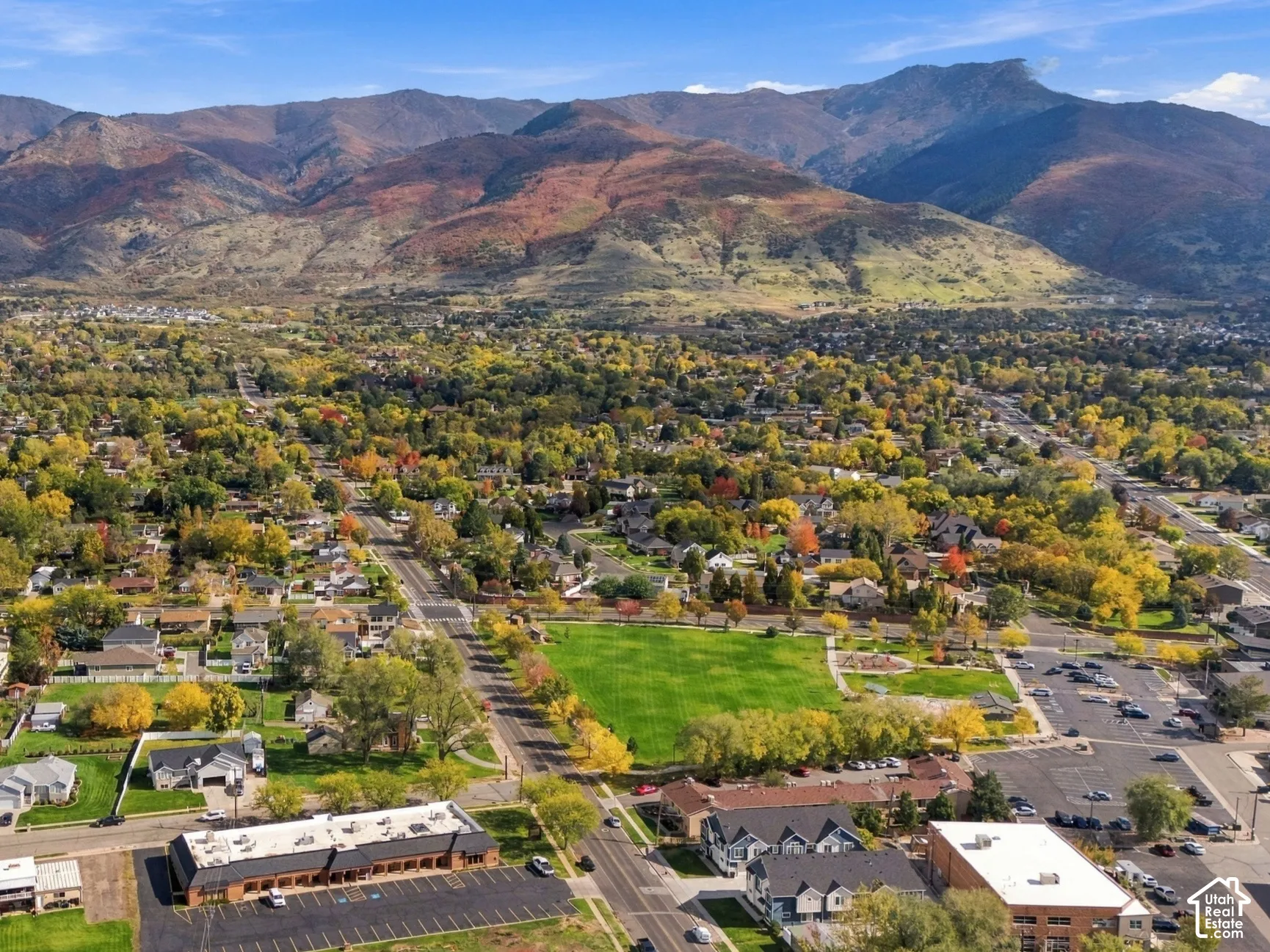 Aerial perspective featuring prominent mountain range backdrop and extensive surrounding greenery