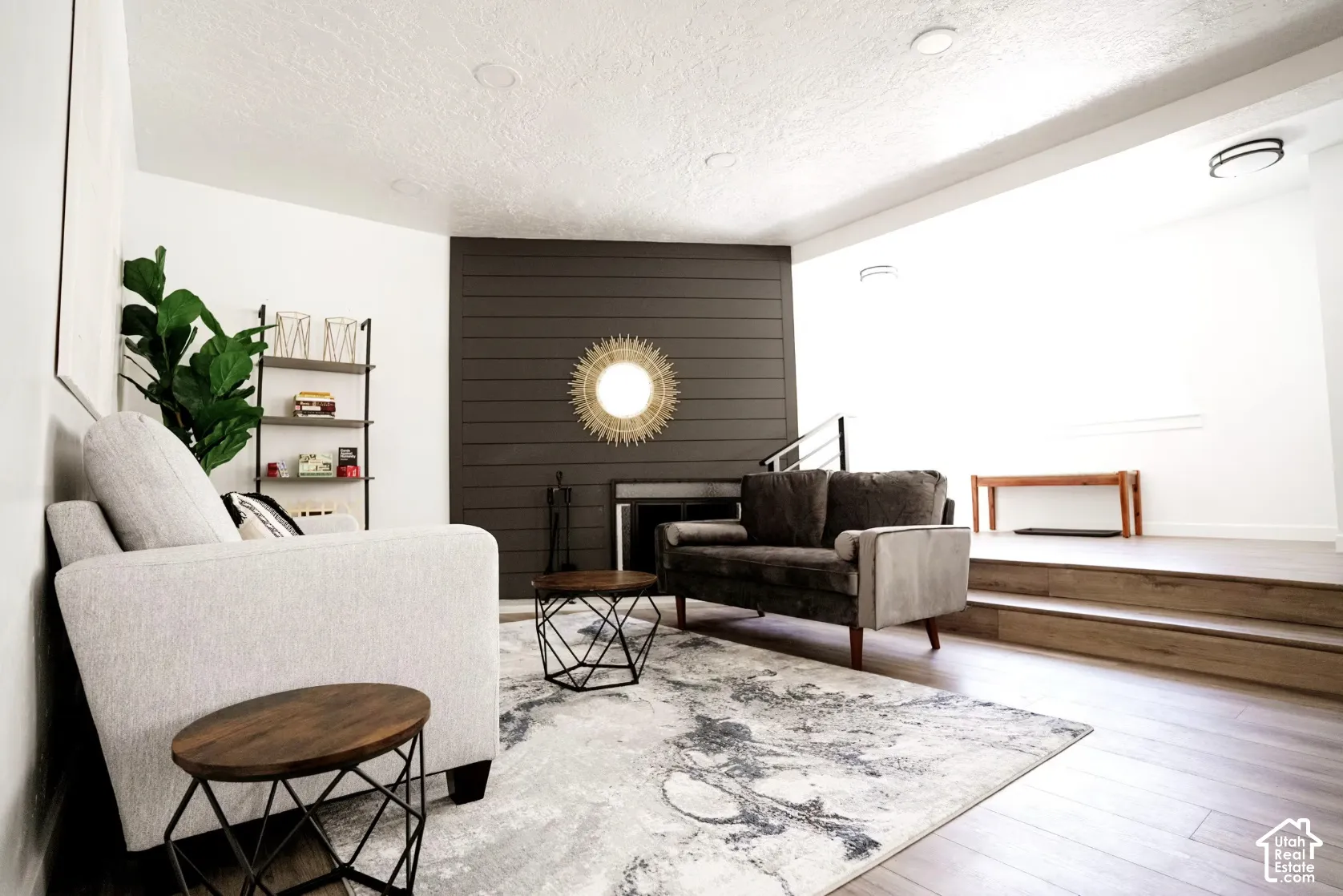 Living area featuring a horizontal plank accent wall, fireplace, wood-finish flooring, and recessed ceiling lighting