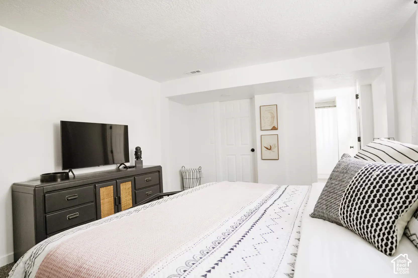 Neutral-toned room featuring a six-panel interior door, textured ceiling, and carpeting